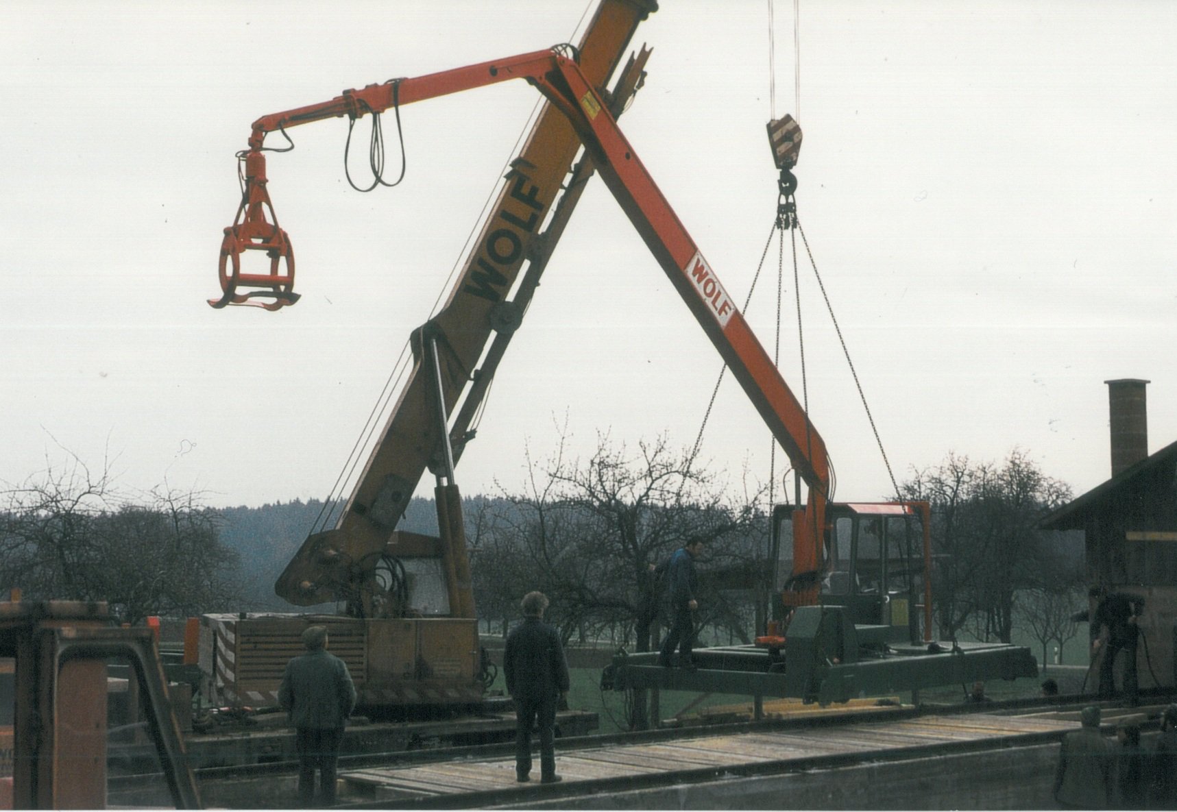 Rundholz-Sortierkran wird mit einem Kranwagen auf die Schienen gesetzt.